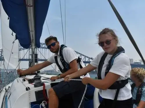 Sailors handling lines aboard a Flying Fish yacht on Sydney Harbour
